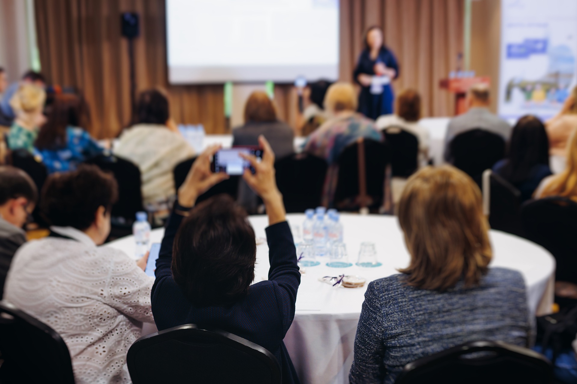 a busy conference laid out in a cabaret arrangement