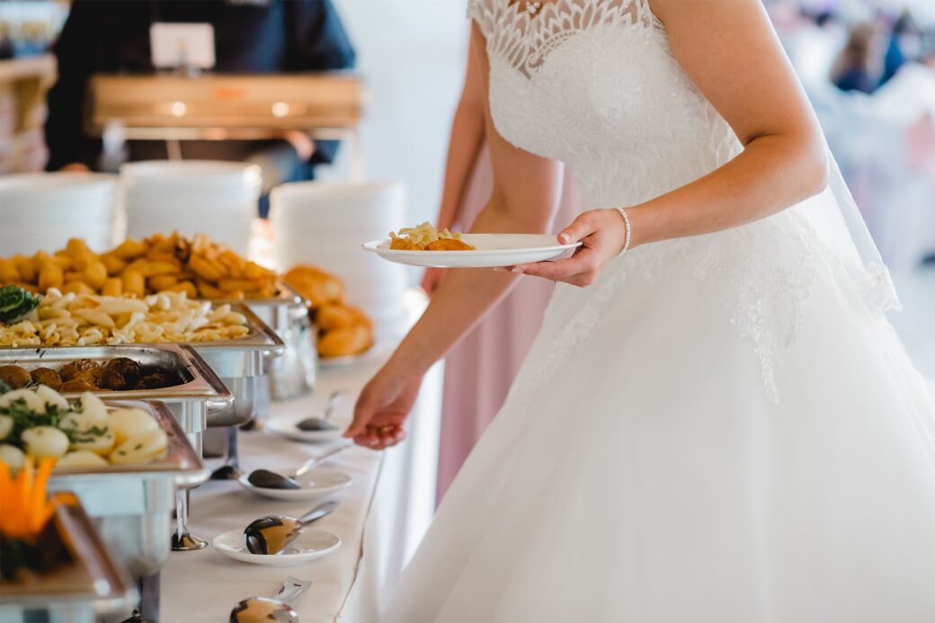 a bride self-serving at a food station for a moderate wedding catering cost